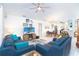 Open-concept living room with blue leather sofas, stylish decor, and direct view into kitchen and dining area at 130 Sand Dollar Ln, Englewood, FL 34223