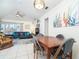 Open-concept living area with living room and dining area, featuring a ceiling fan and neutral decor at 130 Sand Dollar Ln, Englewood, FL 34223