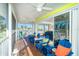 Screened porch featuring outdoor seating, ceiling fans, and views of palm trees and neighborhood at 130 Sand Dollar Ln, Englewood, FL 34223