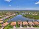 Aerial photo featuring a home with a well-manicured lawn, and landscaping, in a lakefront community at 13000 N Marsh Dr, Port Charlotte, FL 33953