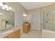 Well-lit bathroom featuring granite countertops, double sinks, and a glass-enclosed walk-in shower for convenience at 13000 N Marsh Dr, Port Charlotte, FL 33953