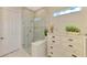 Bathroom featuring a glass-enclosed walk-in shower, linen closet, and tiled walls at 13000 N Marsh Dr, Port Charlotte, FL 33953