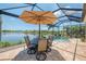Outdoor patio with pool, lake views, dining set, and an umbrella at 13000 N Marsh Dr, Port Charlotte, FL 33953