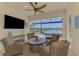 Screened-in patio overlooking a lake with comfortable seating and outdoor television at 13000 N Marsh Dr, Port Charlotte, FL 33953