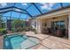 Screened-in pool area with patio furniture, a pool, and lovely landscaping at 13000 N Marsh Dr, Port Charlotte, FL 33953