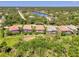 Aerial view showcases the home's screened pool, tropical landscaping, and vibrant community near a tranquil lake at 13217 Scrub Jay Ct, Port Charlotte, FL 33953