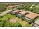 Aerial view of homes with screened pools, lush landscaping, and vibrant green lawns in a quiet neighborhood at 13217 Scrub Jay Ct, Port Charlotte, FL 33953