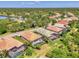 Aerial view of multiple homes with screened pools, tropical landscaping, and serene lake in a Florida neighborhood at 13217 Scrub Jay Ct, Port Charlotte, FL 33953