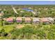 Aerial view of homes with screened-in pools, lush landscaping, and serene lake in a tropical Florida neighborhood at 13217 Scrub Jay Ct, Port Charlotte, FL 33953
