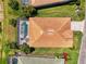 Overhead shot of a home highlighting the screened-in pool, well-manicured lawn, and mature tropical landscaping at 13217 Scrub Jay Ct, Port Charlotte, FL 33953