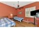 Comfortable bedroom with two twin beds, wood floors, ceiling fan, and a window with shutters at 13217 Scrub Jay Ct, Port Charlotte, FL 33953