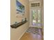 Bright foyer featuring a decorative shelf, stylish rug, tile floors, and a glass front door at 13217 Scrub Jay Ct, Port Charlotte, FL 33953