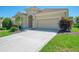Charming single-story home featuring a red tile roof, manicured lawn, and a two-car garage at 13217 Scrub Jay Ct, Port Charlotte, FL 33953