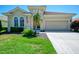 Charming single-story home featuring a red tile roof, manicured lawn, and a two-car garage at 13217 Scrub Jay Ct, Port Charlotte, FL 33953