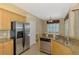 Functional kitchen with stainless steel refrigerator, granite countertops, and convenient dishwasher at 13217 Scrub Jay Ct, Port Charlotte, FL 33953