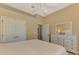 Bright bedroom featuring neutral walls, white trim, ceiling fan, and a large dresser with a mirror at 13217 Scrub Jay Ct, Port Charlotte, FL 33953