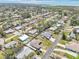 Expansive aerial view of a residential neighborhood near the water, showcasing tidy streets and lush green spaces at 1365 Sussex Rd, Venice, FL 34293