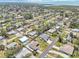 Expansive aerial view of a residential neighborhood near the water, showcasing tidy streets and lush green spaces at 1365 Sussex Rd, Venice, FL 34293