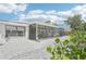 Back exterior showcasing low-maintenance gravel landscaping, screened-in patio, and the overall property design at 1365 Sussex Rd, Venice, FL 34293