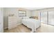 Bedroom with a sliding glass door and neutral tones, complemented by a light-colored dresser at 1365 Sussex Rd, Venice, FL 34293