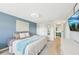 Relaxing bedroom with calming blue walls, modern lighting, and an ensuite bathroom access at 1365 Sussex Rd, Venice, FL 34293