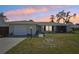 Charming single-story home with a well-manicured lawn, featuring a garage and lovely landscaping details at 1365 Sussex Rd, Venice, FL 34293