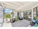 Relaxing screened patio with wicker furniture, patterned rug, and views of the backyard through sliding glass doors at 1365 Sussex Rd, Venice, FL 34293