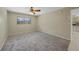 An empty bedroom showcases neutral carpeting, a ceiling fan, and a window with views of the exterior at 1386 Dewitt St, Port Charlotte, FL 33952
