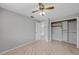 Clean, neutral bedroom features hardwood floors, a ceiling fan, and a closet for ample storage at 1386 Dewitt St, Port Charlotte, FL 33952