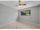 A bright bedroom with hardwood floors, a ceiling fan, and a window overlooking the property at 1386 Dewitt St, Port Charlotte, FL 33952