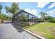A view of the yard with the screened pool enclosure and plenty of green space at 1386 Dewitt St, Port Charlotte, FL 33952