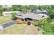 Charming single-story home with a gray roof, lush landscaping, and a detached garage at 1386 Dewitt St, Port Charlotte, FL 33952