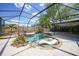 Backyard pool with waterfall features, mature landscaping, and a screened enclosure to enjoy the outdoors at 1386 Dewitt St, Port Charlotte, FL 33952
