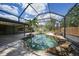 Backyard pool featuring stone waterfalls, water features, and a screened enclosure to enjoy the outdoors at 1386 Dewitt St, Port Charlotte, FL 33952