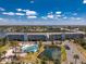 Aerial view of the community amenities: tennis court, pool, pond, and condo buildings with water views at 1401 S Mccall Rd # A 108, Englewood, FL 34223