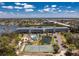 Aerial view of the community amenities: tennis court, pool, pond, and condo buildings with water views at 1401 S Mccall Rd # A 108, Englewood, FL 34223
