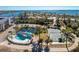 Aerial view of the community amenities: tennis court, pool, pond, and condo buildings in the background at 1401 S Mccall Rd # A 108, Englewood, FL 34223