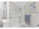 Bright bathroom showcasing a shower-tub combination with glass doors and a neutral color palette at 1401 S Mccall Rd # A 108, Englewood, FL 34223