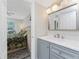 Updated bathroom with gray vanity, marble countertop and view to bedroom at 1401 S Mccall Rd # A 108, Englewood, FL 34223