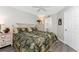 Bright bedroom features ceiling fan, wood-look floors, tropical-themed bedding and ensuite bath at 1401 S Mccall Rd # A 108, Englewood, FL 34223