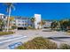Exterior of the condo building showing the parking lot, landscaping, and multiple levels of balconies at 1401 S Mccall Rd # A 108, Englewood, FL 34223