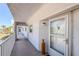 Exterior hallway leading to condo entrance, with textured walls, and white railings at 1401 S Mccall Rd # A 108, Englewood, FL 34223