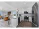 Open-concept kitchen with white cabinets, stainless steel appliances, and a view into the living area at 1401 S Mccall Rd # A 108, Englewood, FL 34223