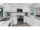 Modern kitchen featuring white cabinets, stainless steel appliances, and granite countertops at 1401 S Mccall Rd # A 108, Englewood, FL 34223