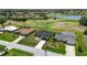 Aerial view of a one story home located on a golf course near a pond and other homes at 166 Bunker Rd, Rotonda West, FL 33947