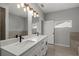 Well-lit bathroom with a dual sink vanity, modern lighting fixtures, and a walk-in shower at 166 Bunker Rd, Rotonda West, FL 33947