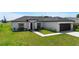Well-maintained one story home with black and white accents and a manicured front lawn at 166 Bunker Rd, Rotonda West, FL 33947