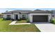 Well-maintained one story home with black and white accents and a manicured front lawn at 166 Bunker Rd, Rotonda West, FL 33947