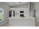 Bright kitchen features white cabinets, stainless steel appliances, and a large center island with quartz countertop at 166 Bunker Rd, Rotonda West, FL 33947