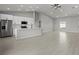Open-concept kitchen features stainless steel appliances, white cabinetry, and a large kitchen island with bar seating at 166 Bunker Rd, Rotonda West, FL 33947